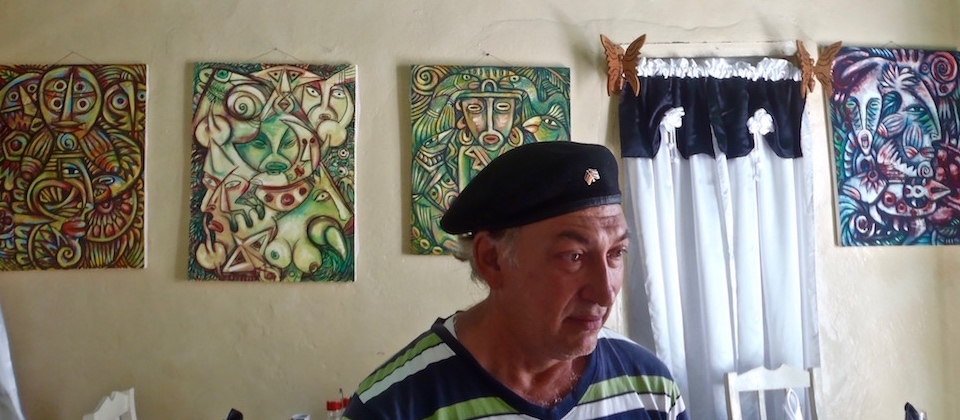 Mildo Matos Carcasés con sus cuadros Baracoa Cuba